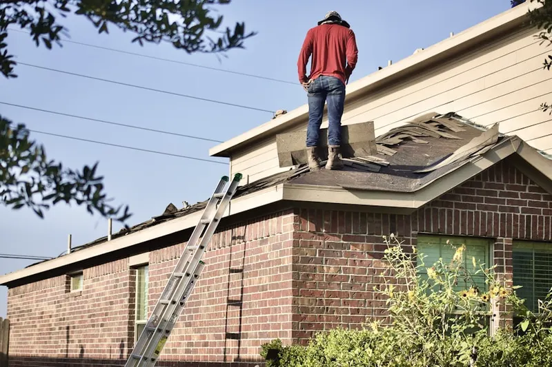 Professional roofer working on a residential roof in Brookfield Manor Mobile Home Park